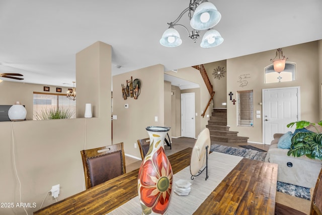 dining room featuring stairway, ceiling fan with notable chandelier, and baseboards