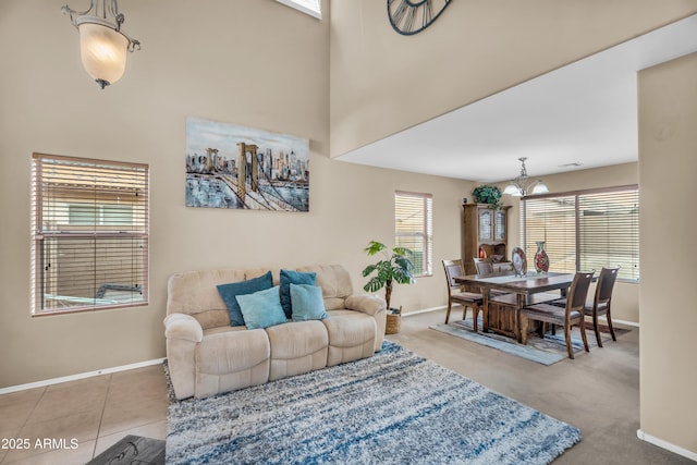 tiled living room with baseboards, an inviting chandelier, and a towering ceiling