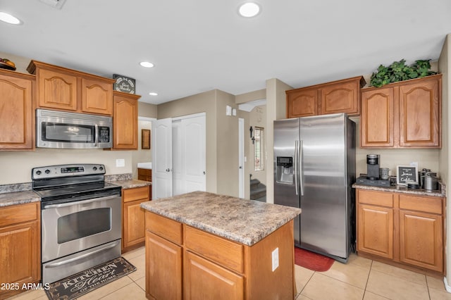kitchen featuring light tile patterned floors, recessed lighting, appliances with stainless steel finishes, and a kitchen island