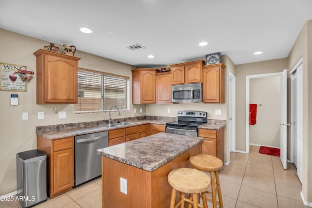 kitchen with visible vents, a breakfast bar area, light tile patterned floors, appliances with stainless steel finishes, and a sink