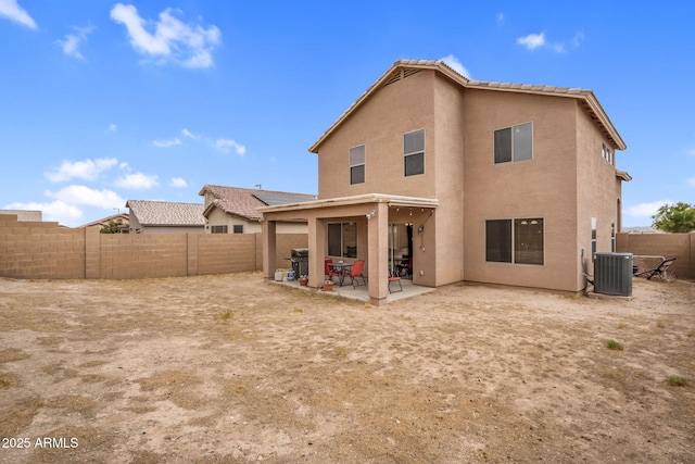 back of house with stucco siding, a tile roof, a fenced backyard, cooling unit, and a patio area