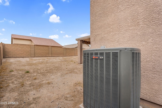 exterior details featuring central AC unit, a fenced backyard, and stucco siding