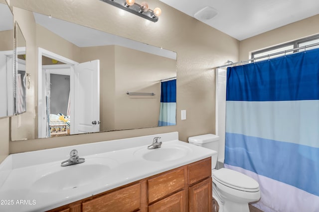 full bathroom featuring double vanity, toilet, shower / tub combo, and a sink