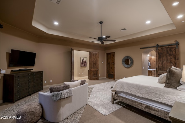 25031 N Paso Trl, Scottsdale, AZ 85255 - bedroom featuring a tray ceiling, recessed lighting, arched walkways, a barn door, and visible vents