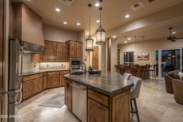 25031 N Paso Trl, Scottsdale, AZ 85255 - kitchen featuring a sink, brown cabinets, custom exhaust hood, stainless steel appliances, and dark countertops