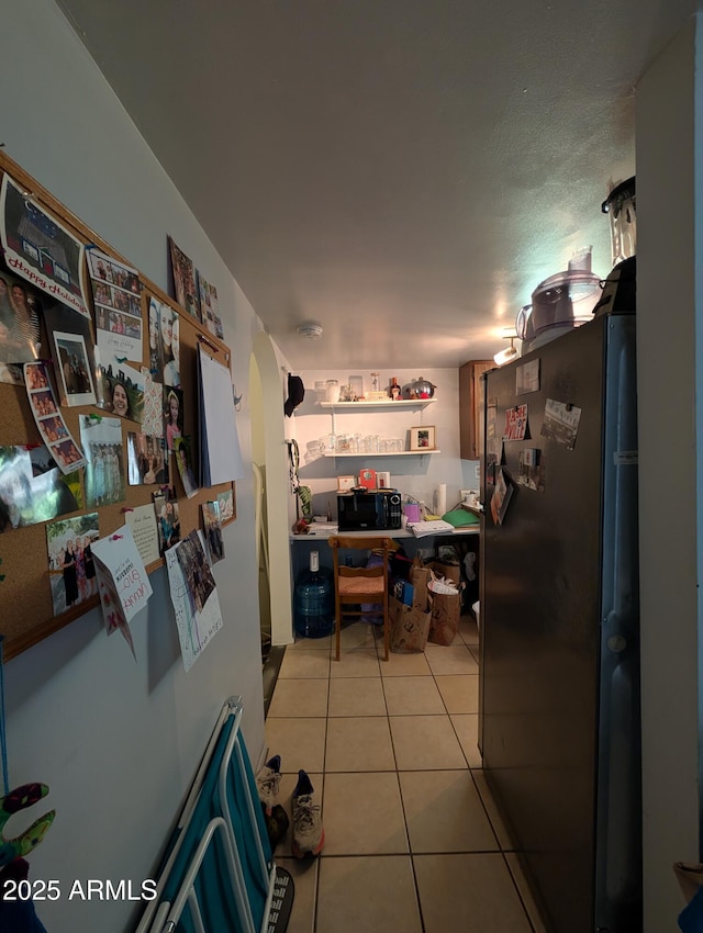 3827 N 8th St, Phoenix, AZ 85014 - kitchen featuring freestanding refrigerator, light tile patterned floors, and black microwave