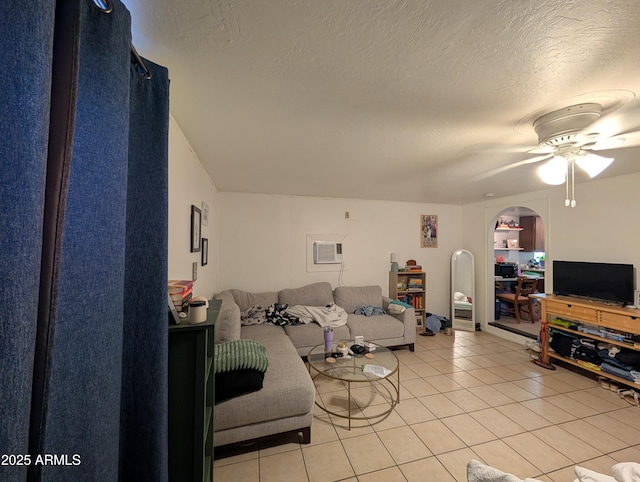 3827 N 8th St, Phoenix, AZ 85014 - living room featuring light tile patterned floors, arched walkways, ceiling fan, a wall mounted air conditioner, and a textured ceiling