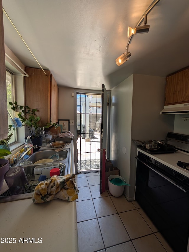 3827 N 8th St, Phoenix, AZ 85014 - kitchen featuring gas range, extractor fan, brown cabinetry, and light tile patterned floors