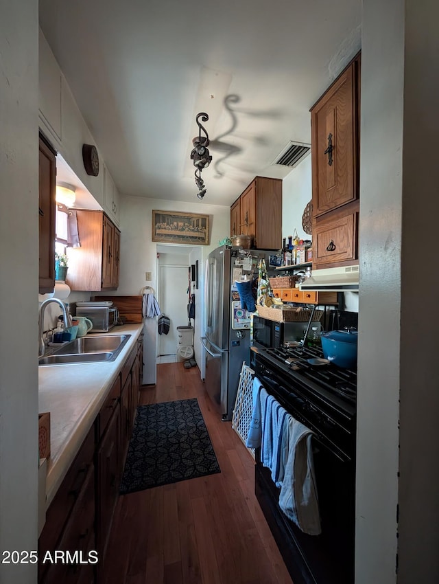 3827 N 8th St, Phoenix, AZ 85014 - kitchen featuring a sink, dark wood finished floors, black range with gas stovetop, brown cabinetry, and under cabinet range hood