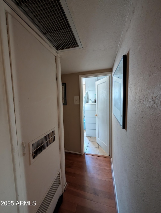 3827 N 8th St, Phoenix, AZ 85014 - hall featuring wood finished floors, a textured wall, and baseboards