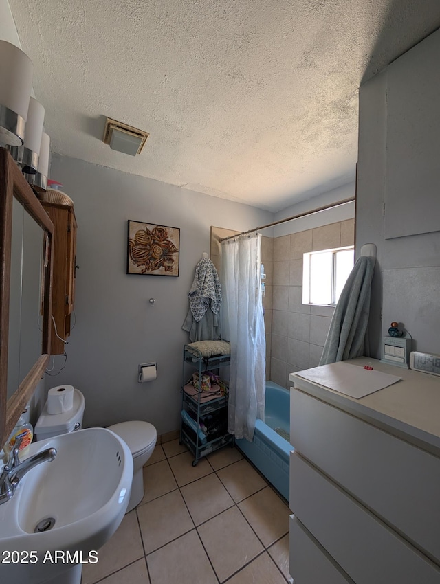 3827 N 8th St, Phoenix, AZ 85014 - full bathroom featuring toilet, tile patterned floors, a textured ceiling, a sink, and shower / bath combination with curtain