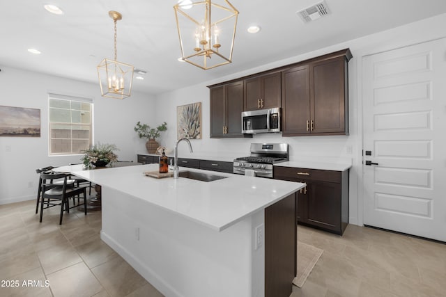 655 S Jacana Ln, Gilbert, AZ 85296 - kitchen featuring stainless steel appliances, a chandelier, a sink, dark brown cabinetry, and a kitchen island with sink