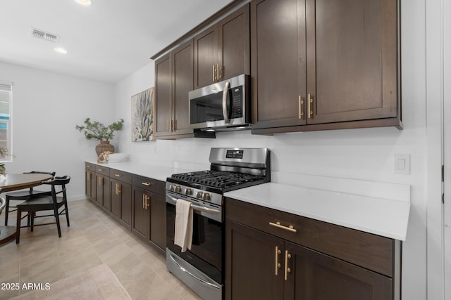 655 S Jacana Ln, Gilbert, AZ 85296 - kitchen with stainless steel appliances, dark brown cabinetry, light countertops, and baseboards
