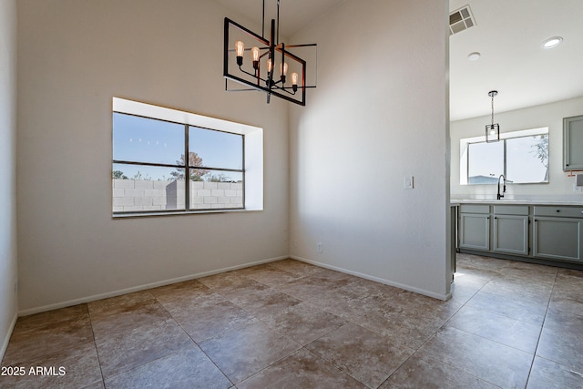 unfurnished dining area featuring an inviting chandelier and sink