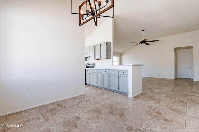 kitchen featuring ceiling fan with notable chandelier and lofted ceiling