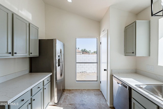 kitchen featuring vaulted ceiling, stainless steel appliances, gray cabinets, and sink