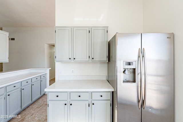 kitchen featuring stainless steel fridge with ice dispenser and white cabinetry