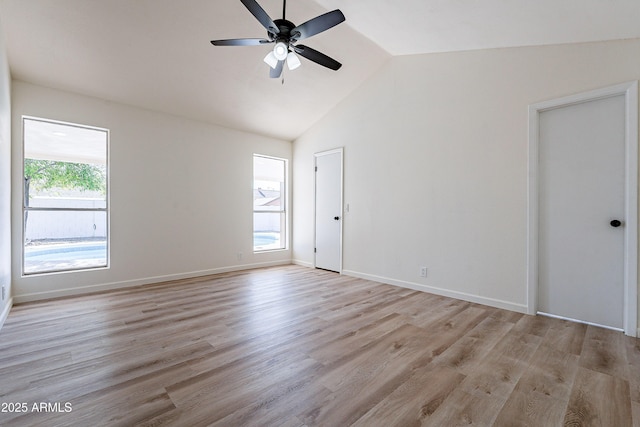 empty room featuring plenty of natural light, light hardwood / wood-style floors, ceiling fan, and vaulted ceiling