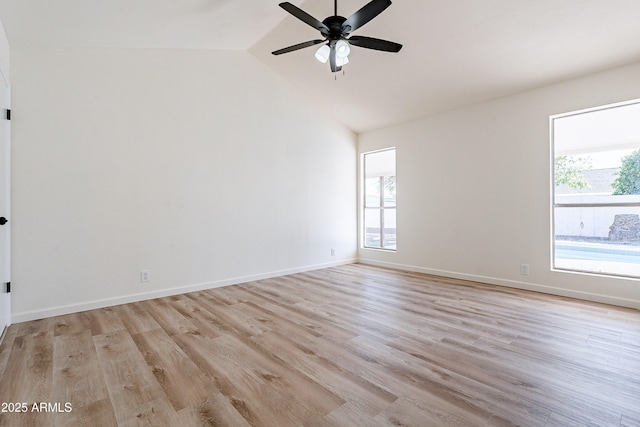 unfurnished room featuring ceiling fan, a healthy amount of sunlight, vaulted ceiling, and light hardwood / wood-style floors