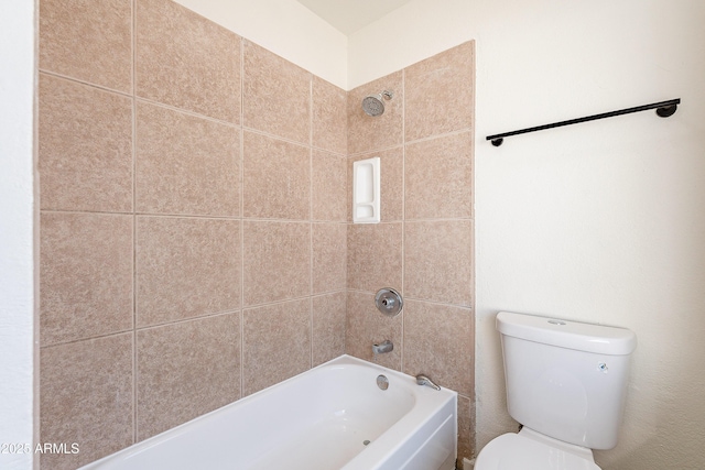 bathroom with toilet and tiled shower / bath