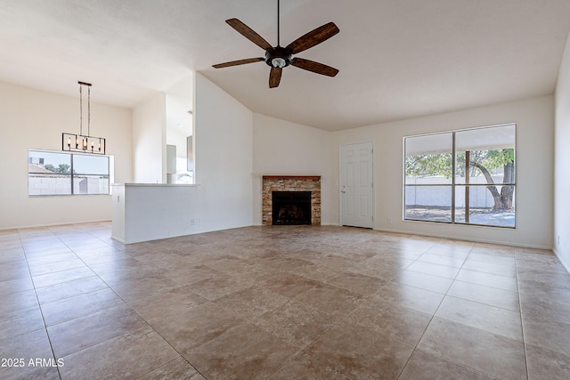 unfurnished living room with ceiling fan with notable chandelier, a stone fireplace, and light tile patterned floors