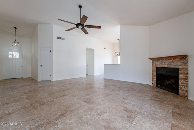 unfurnished living room featuring a stone fireplace, ceiling fan, and lofted ceiling