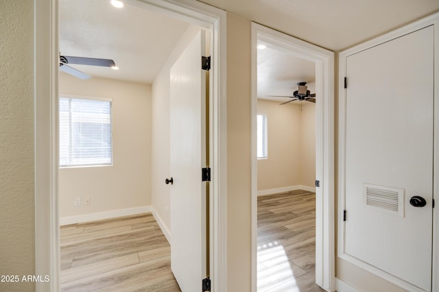 hallway with light hardwood / wood-style floors