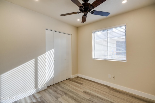 unfurnished bedroom featuring ceiling fan, light wood-type flooring, and a closet