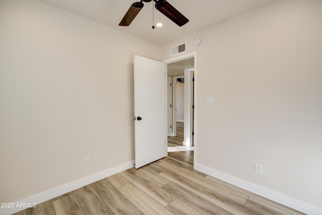 empty room with ceiling fan and light hardwood / wood-style flooring