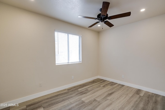 spare room with ceiling fan and light wood-type flooring