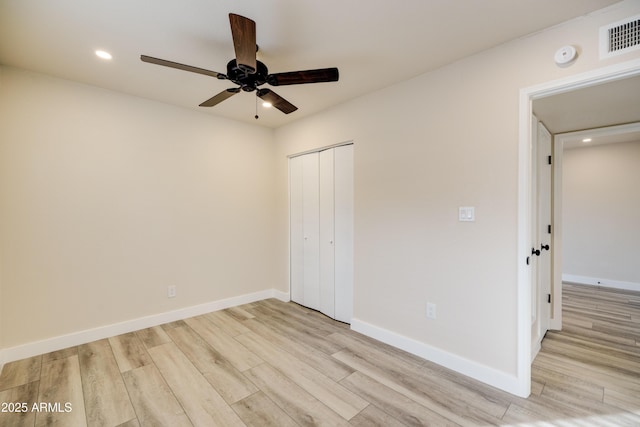 unfurnished bedroom with ceiling fan, light wood-type flooring, and a closet