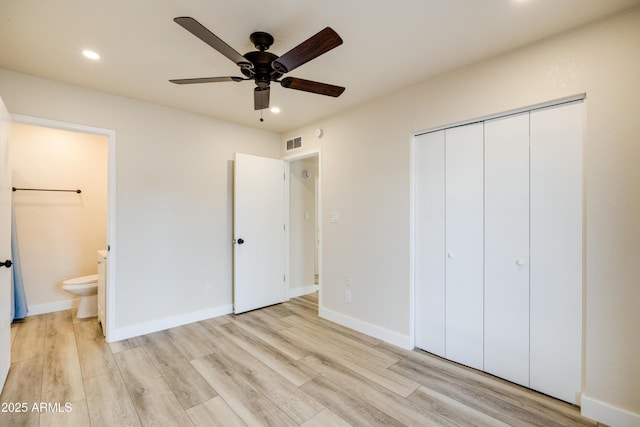 unfurnished bedroom with connected bathroom, light hardwood / wood-style floors, and a closet