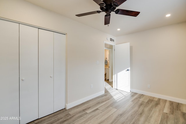 unfurnished bedroom featuring light hardwood / wood-style floors, a closet, and ceiling fan