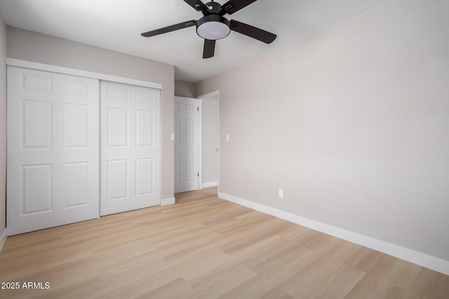 unfurnished bedroom featuring ceiling fan, light wood-type flooring, and a closet