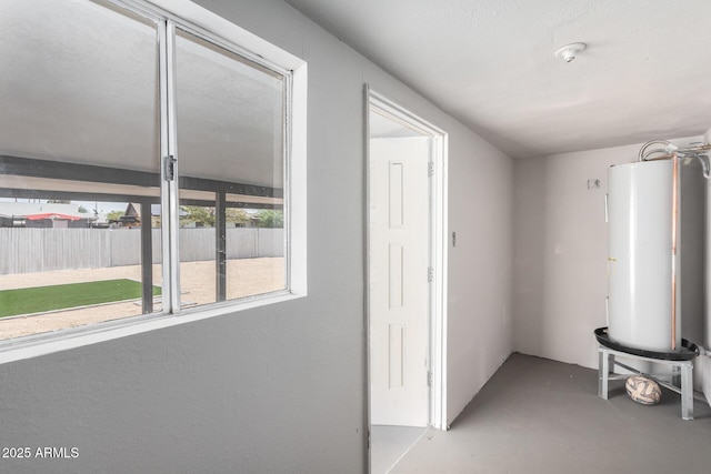 hall with concrete flooring and gas water heater