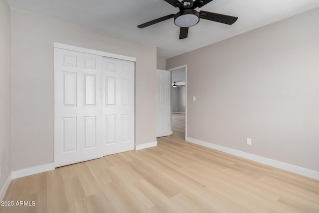 unfurnished bedroom with ceiling fan, a closet, and light wood-type flooring