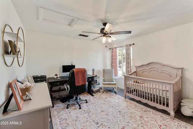 carpeted bedroom with a ceiling fan, visible vents, baseboards, attic access, and a nursery area