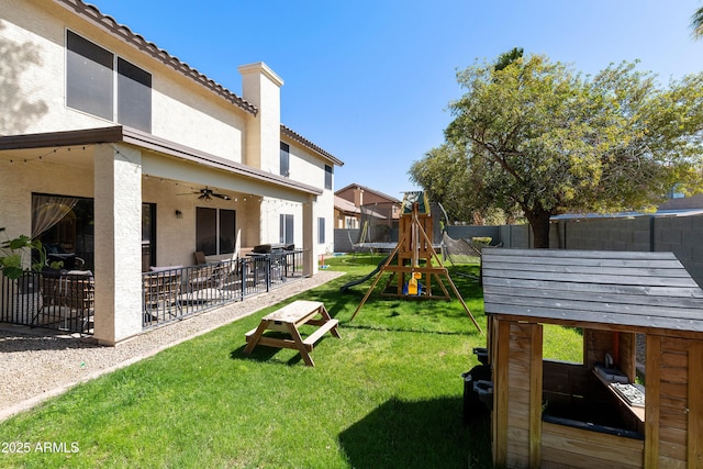 view of yard featuring a patio area, a trampoline, a fenced backyard, and a playground