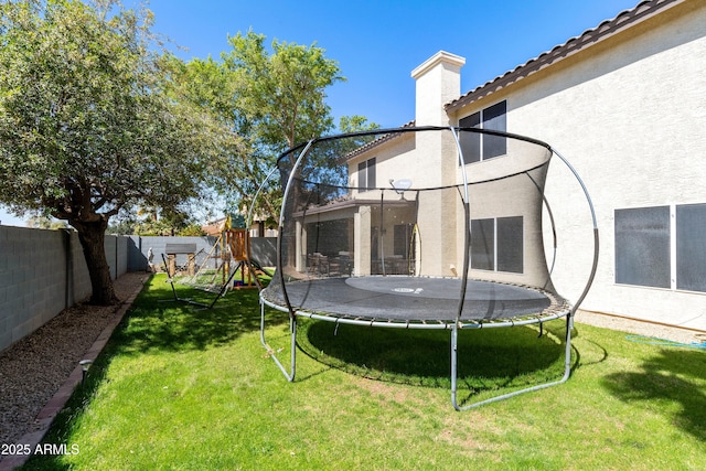 view of yard with a playground, a trampoline, and a fenced backyard