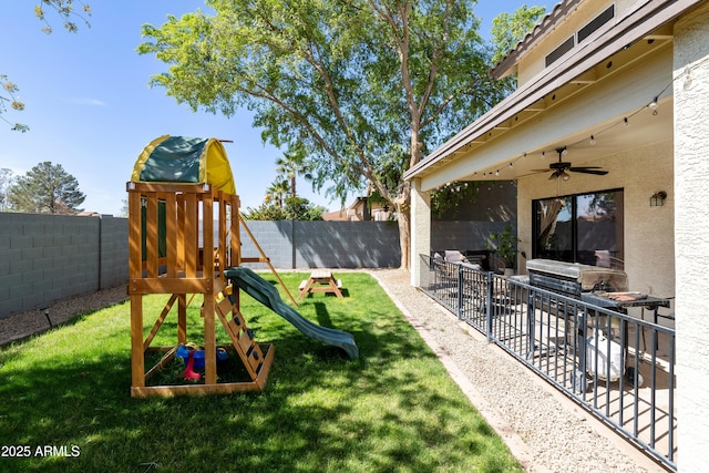 view of yard featuring a patio area, ceiling fan, a playground, and a fenced backyard