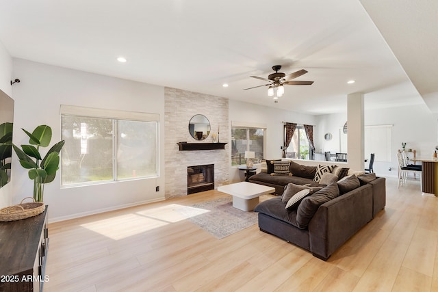 living area featuring recessed lighting, a ceiling fan, light wood-style floors, and a fireplace