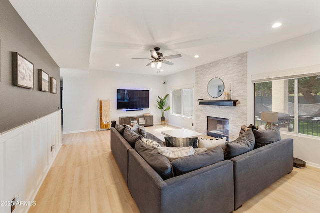 living room featuring light wood finished floors, a wainscoted wall, recessed lighting, and a fireplace