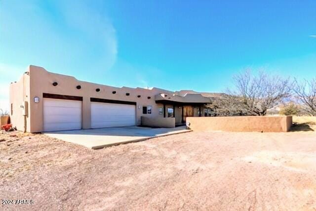 pueblo-style home with a garage