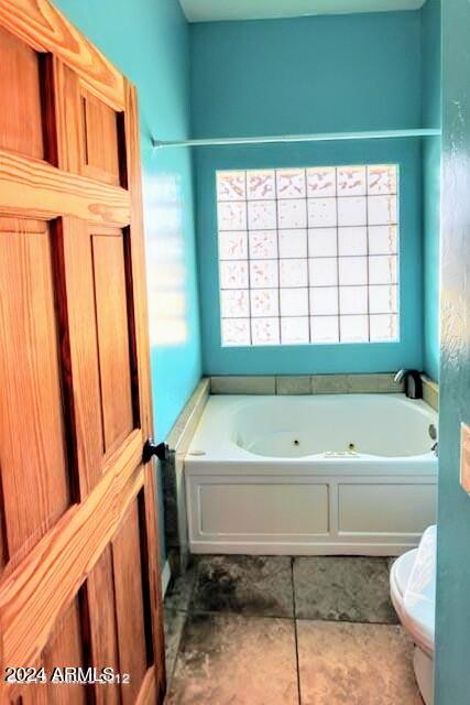 bathroom featuring a tub to relax in and toilet