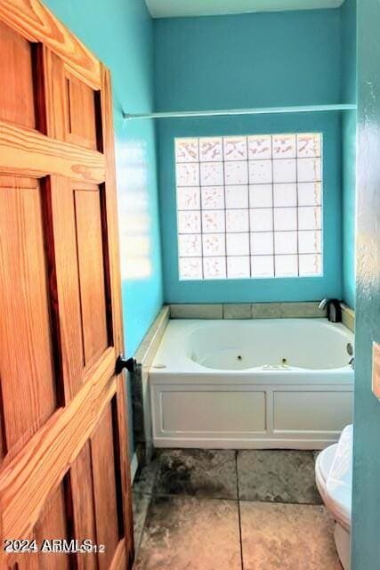 bathroom with plenty of natural light, toilet, and a garden tub