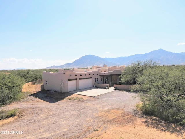 pueblo-style home featuring a mountain view and a garage