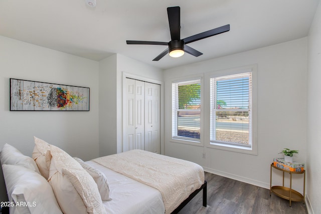 bedroom featuring dark wood finished floors, baseboards, a closet, and a ceiling fan