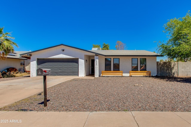 single story home featuring driveway, an attached garage, and fence