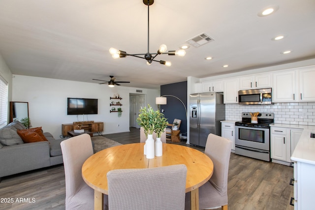 dining area featuring a chandelier, ceiling fan, dark wood-style floors, and recessed lighting