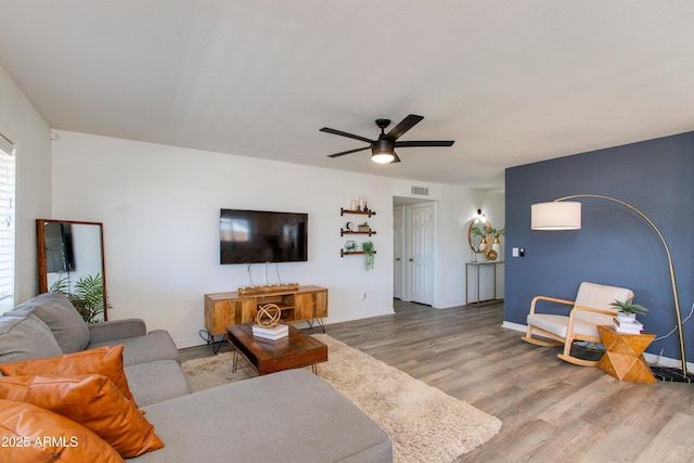living area with wood finished floors, ceiling fan, and baseboards